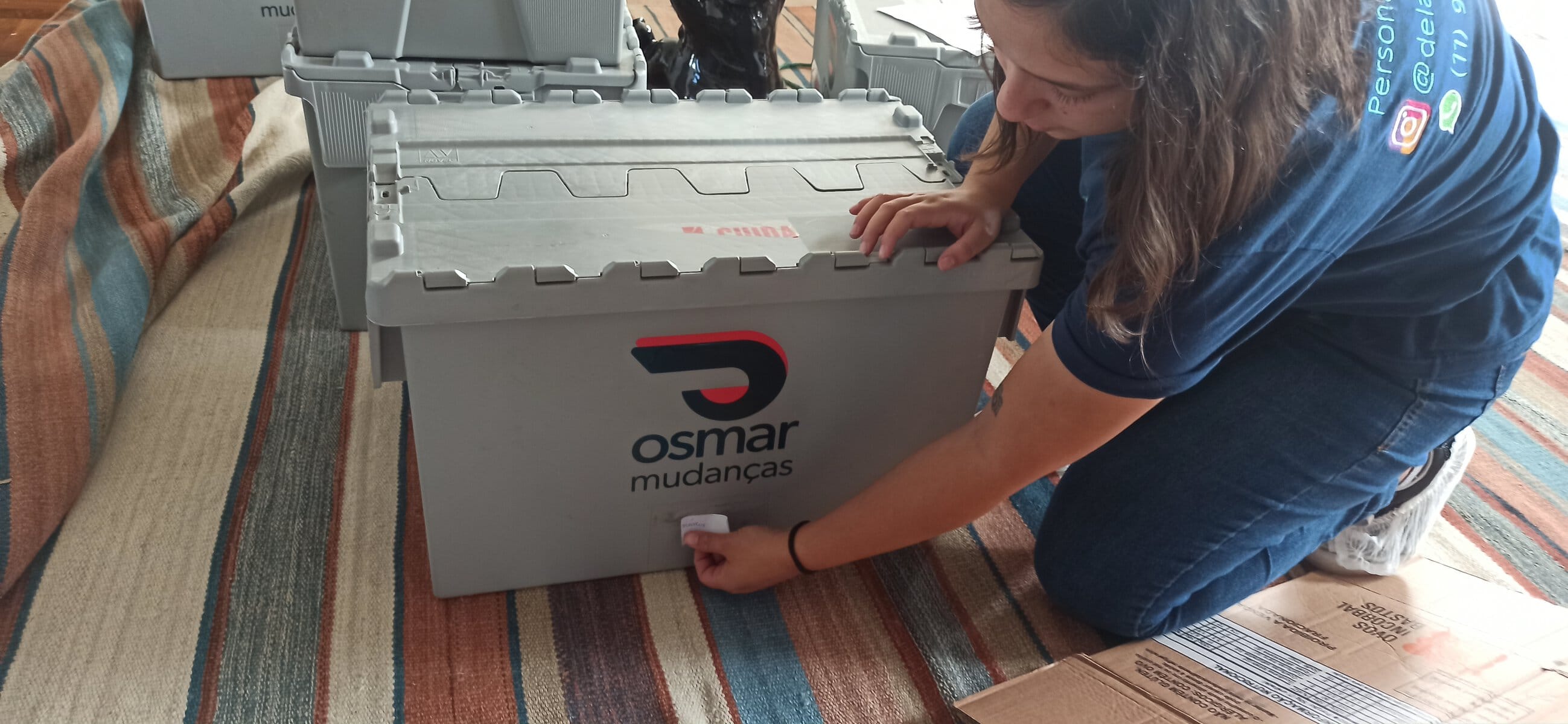 Profissional da Osmar etiquetando uma caixa durante o encaixotamento