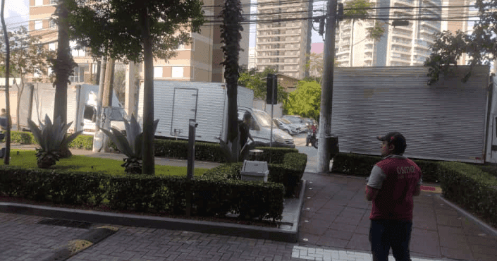 Caminhão da Osmar em frente a um prédio comercial no dia da mudança