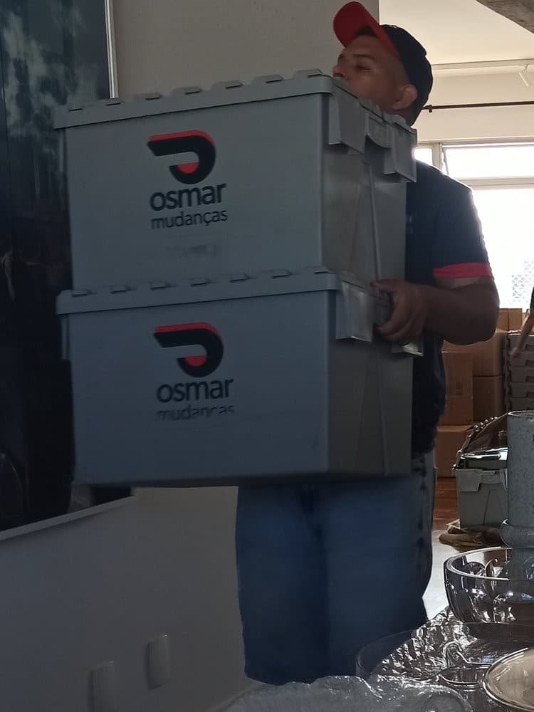 Ajudante da Osmar carregando caixas plásticas da empresa