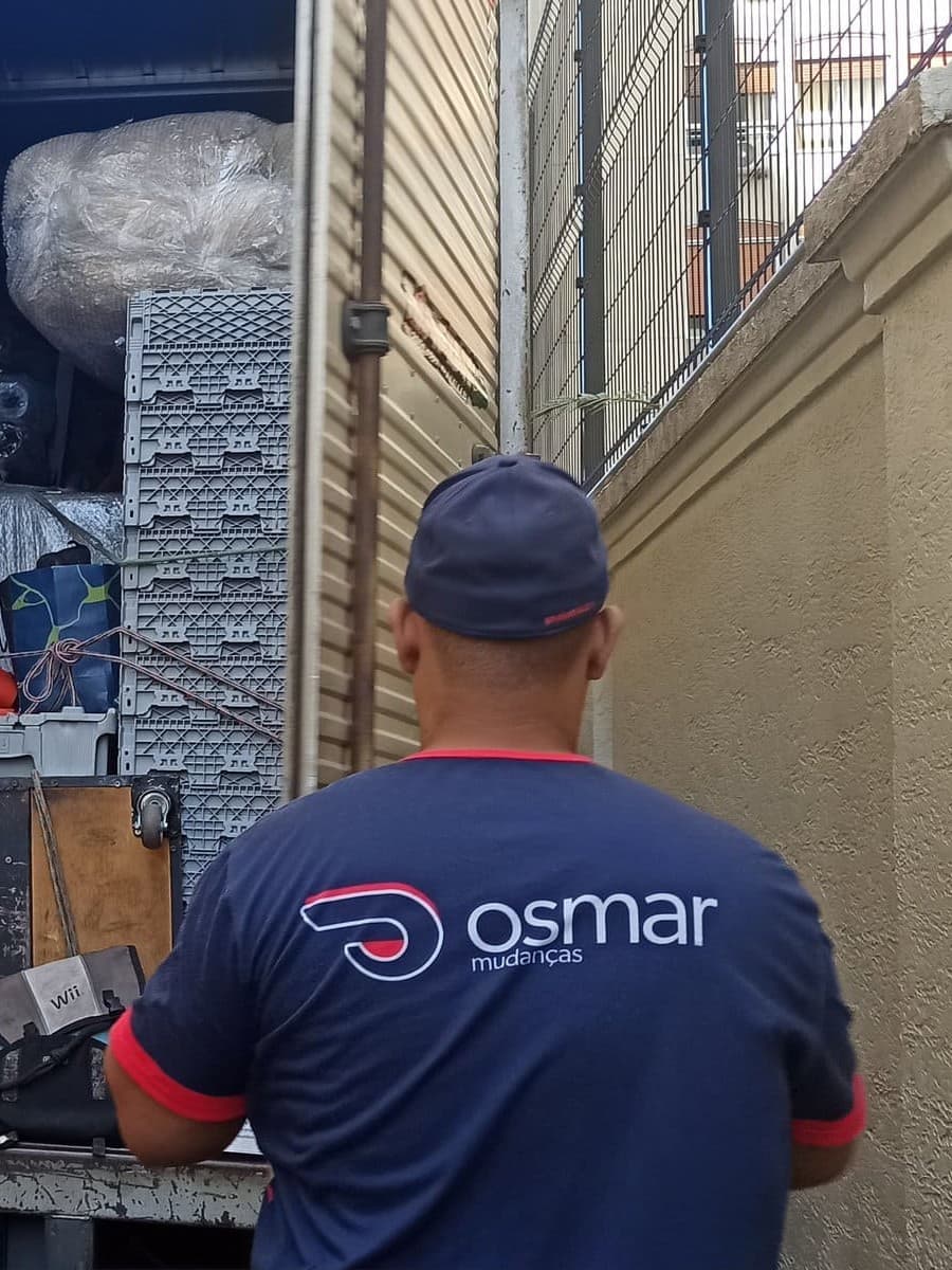 Ajudante da Osmar organizando a carga protegida dentro do caminhão