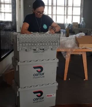 Personal organizer da Osmar encaixotando itens em caixas plásticas