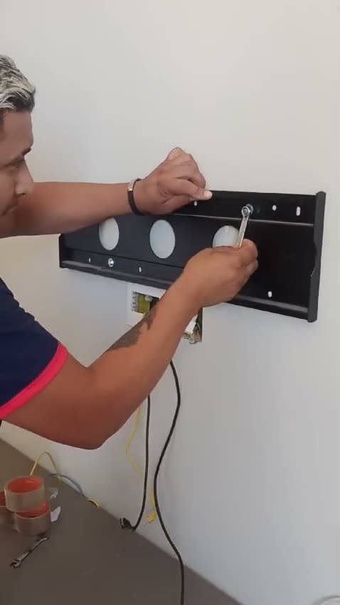 Profissional da Osmar instalando um suporte de parede