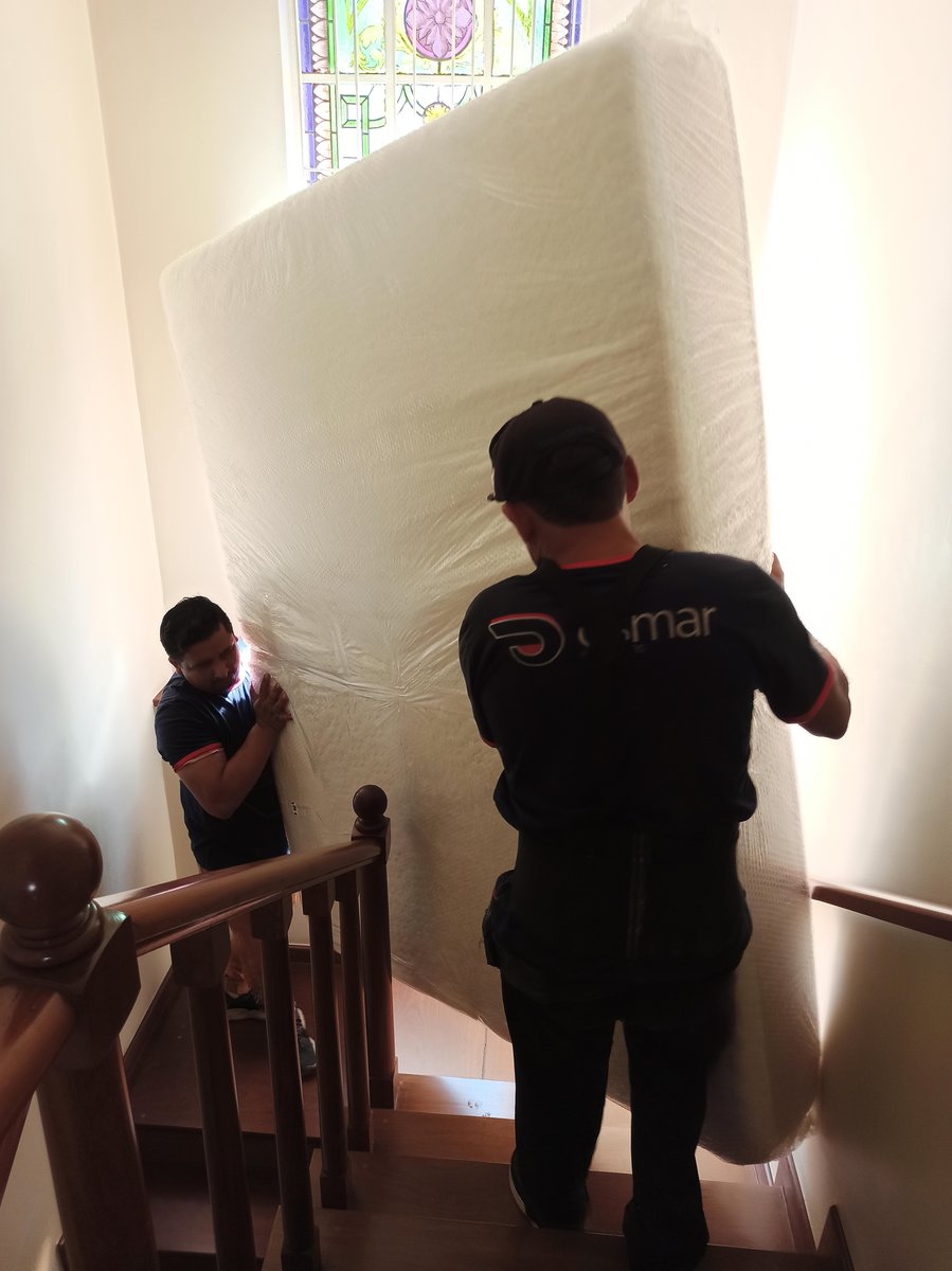 ajudante descendo colchão pela escada