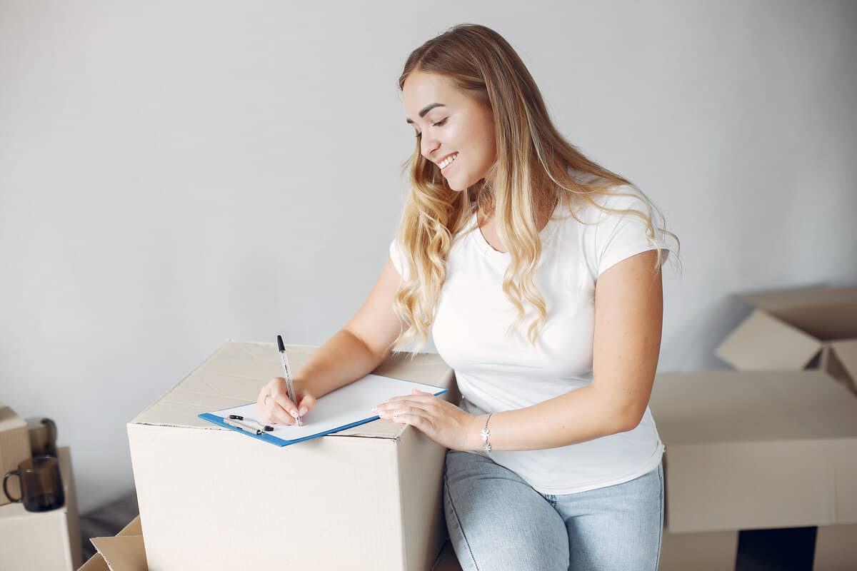 woman moving using checklist on boxes