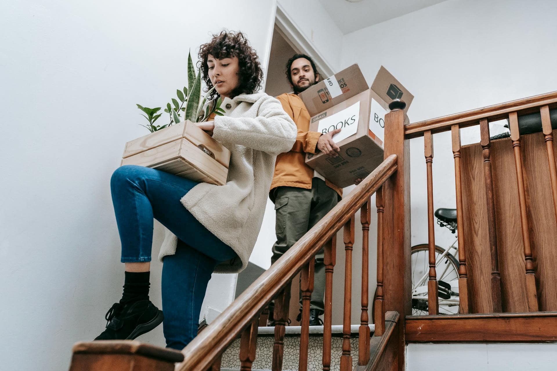 casal descendo escadas com caixas