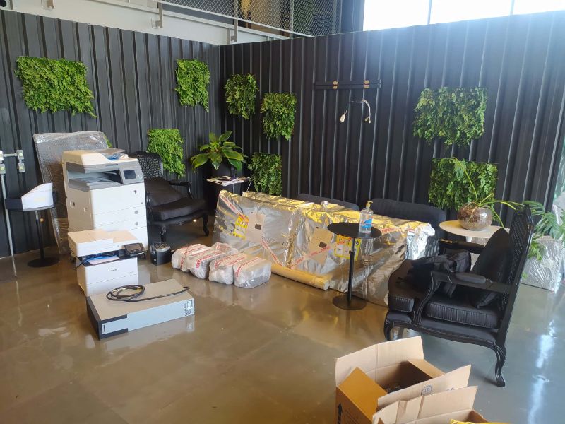 Caminhão de mudança comercial sendo carregado por equipe profissional com caixas e móveis organizados